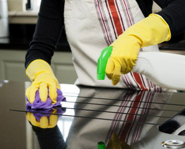 A person in yellow gloves cleaning the counter top.
